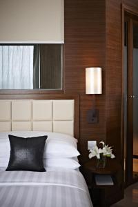 香港香港观塘帝盛酒店的一间卧室配有一张床和一张带台灯的桌子