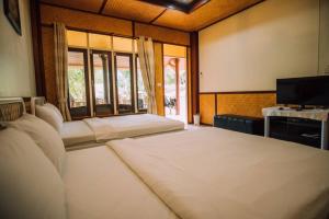 塞友Baanpufa Resort的客房设有两张床、一台电视和窗户。