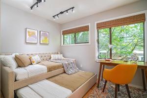 贝尔维尤Sunlit contemporary Bellevue Home w a Lush Garden的一间带沙发、书桌和窗户的卧室