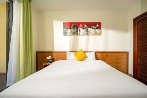 会安Palm Boutique Village - STAY 24H的卧室配有一张白色大床和黄色枕头