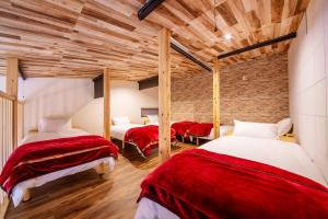 千葉地域ランキング1位獲得の贅沢な貸別荘全4棟的一间设有三张红色和白色床单的房间