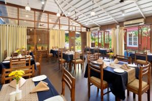 坎多林Aldeia Santa Rita - Candolim的餐厅设有蓝色的桌椅和窗户。