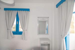 弗伊尼基昂GIAVASI SEASIDE FINIKI的浴室拥有白色的墙壁和蓝色的窗户。