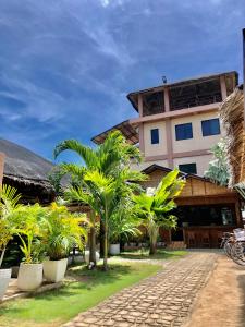 班塔延岛Anahaw Seaside Inn的一座棕榈树度假村,位于一座建筑前