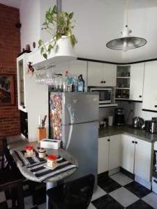 上格拉西亚La casa de Lily的厨房配有冰箱和带食品的桌子。