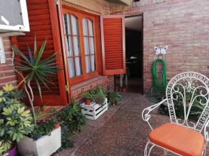 上格拉西亚La casa de Lily的一个带白色椅子的门廊和一些植物