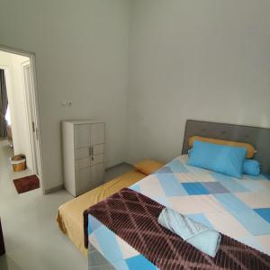 巴图Kayana Regency F7的一间卧室配有一张带蓝色枕头的床和橱柜