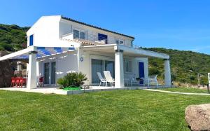 卡斯特尔萨多Primaguadia Luxury Villa的草坪上带椅子的白色房子