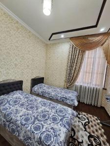 布哈拉Новая 3-х комнатная квартира Мечта的一间卧室设有两张床和窗户。