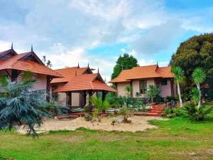 瓜拉丁加奴Inap Kota sang rimba的一座带橙色屋顶和庭院的房子