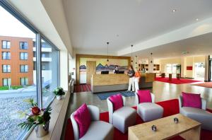 沃尔肯施泰因桑特皇家酒店 - 格桑恩斯里特瓦姆巴德施泰因的办公室大堂配有红色和白色的家具和粉红色的枕头