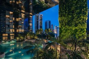 新加坡乌节泛太平洋酒店的享有棕榈树和建筑的游泳池的顶部景致