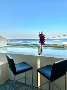 法里拉基沙湾海滩旅馆的酒吧配有两把椅子和一瓶葡萄酒