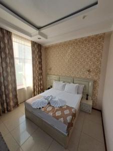 塔什干Sofiya Tashkent Hotel的一间卧室配有一张床,上面有两条毛巾