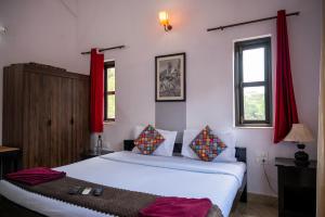 马普萨RONNE'S VILLA De SOL-3BHK LUXURY VILLA In Assagaon的卧室配有白色的床和红色窗帘