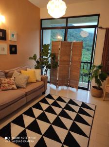 峇都丁宜近海滩珍洁舒适公寓的带沙发和大窗户的客厅