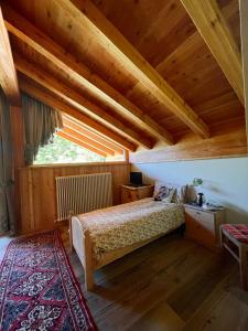 费拉迪普利米罗B&B Maso al Cervo的一间卧室设有一张床和木制天花板
