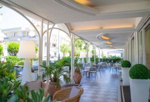 里乔内达瑟纳酒店的大堂设有桌椅和植物