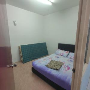 玻璃市港口THIFFAH HOMESTAY KUALA PERLIS的一间卧室配有一张带紫色棉被的床
