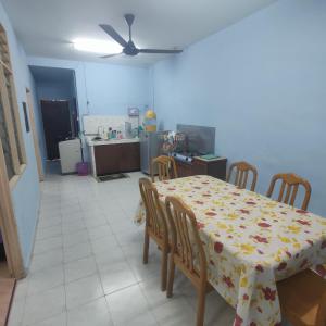 玻璃市港口THIFFAH HOMESTAY KUALA PERLIS的一间带桌椅的用餐室和一间厨房