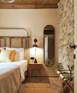 PírgosPyrgi Cretan Living & Spa的一间卧室配有一张带镜子和桌子的床