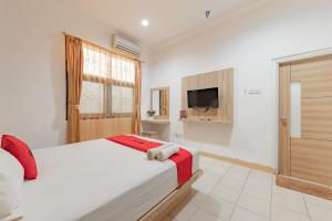 Klandasan KecilRedDoorz Syariah near Taman Bekapai 2的一间卧室配有一张大床和电视