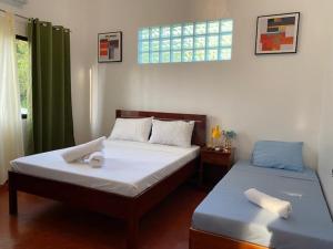 曼巴豪Tongatok Cliff Resort的一间卧室设有两张床和窗户。
