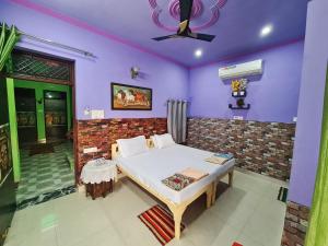 阿格拉安努科姆帕宾馆的一间拥有紫色墙壁的卧室和一张床铺
