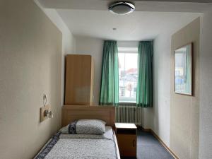 梅尔齐希Hotel Roma的一间卧室设有两张床,窗户设有绿色窗帘