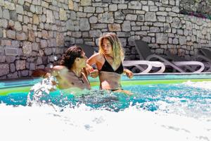 布雷佐内加尔达Agricampeggio Paradiso的两个女人在游泳池里玩耍