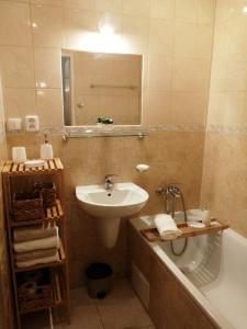 科马尔诺Apartman Classic的浴室配有盥洗盆、浴缸和盥洗盆