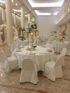 贝鲁特Riviera Hotel and Beach Lounge, Beirut的宴会厅配有白色的桌子和白色的椅子