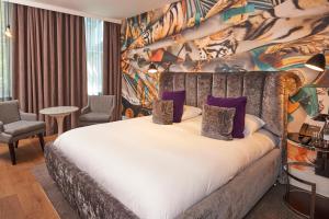 伦敦马尔马逊伦敦酒店的一间卧室配有一张带紫色枕头的大床