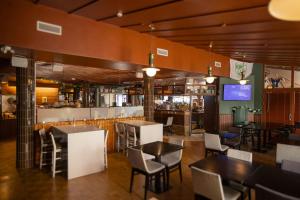 玛丽港阿德隆酒店的一间带桌椅的餐厅和一间酒吧