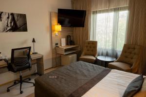 玛丽港潘美酒店的酒店客房,配有一张床、一张桌子和椅子