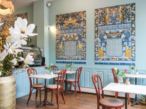 阿姆斯特丹T酒店的餐厅设有白色的桌椅和蓝色的墙壁