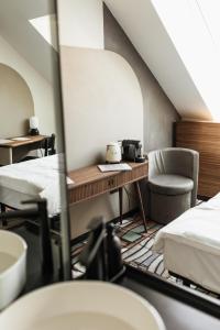 布达佩斯Hotel GIN Budapest的一间设有两张床、一张桌子和一把椅子的房间