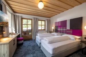 图克斯辛特图塞尔霍夫儿童与冰川酒店的一间带两张床的卧室,位于木天花板的房间