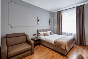基辅经典酒店 的一间卧室配有一张床和一把椅子