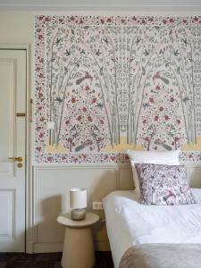 阿姆斯特丹T酒店的一间卧室配有一张带花卉壁纸的床