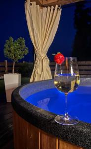 拉普斯尼恩Dom na Zielonym Wzgórzu z własną Sauną i Jacuzzi的热水浴池中的一杯葡萄酒和草莓