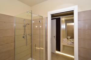 比森齐奥营M2 Hotel的带淋浴的浴室和玻璃门