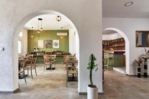 赫索尼索斯Charm Hotel, Hersonissos的餐厅设有拱门和桌椅