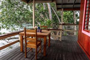 Leleana Resort Kolombangara Island的门廊上的木桌和椅子