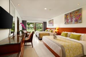 库塔巴厘岛王朝假日酒店的酒店客房配有两张床和一张书桌