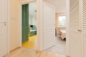 普鲁什库夫Spacious & Quiet 1 Bedroom Apartment in Pruszków by Renters的走廊设有一扇门,通往一间带浴缸的浴室
