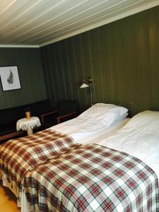 TrettenGlomstad Gjestehus的一间卧室配有一张带 ⁇ 子毯子的床