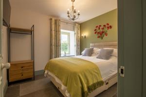 Ravensworth3 Mill Cottages的一间卧室配有一张带黄色毯子和窗户的床
