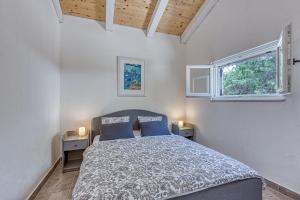 康斯基Eco House Casa Grigia - Happy Rentals的一间卧室设有一张床和两个窗户。