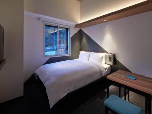 热海熱海王子智能酒店(Prince Smart Inn Atami)的酒店客房设有床和窗户。